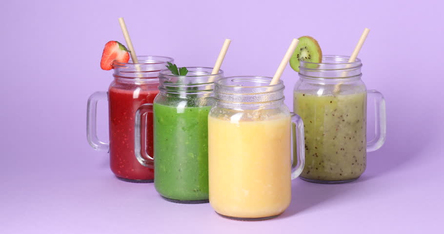 Woman taking smoothie on purple background, closeup