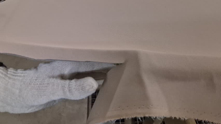 Fabric cutting textile industry manual work worker trims excess material with scissors manufacturing process