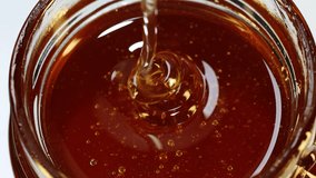 Honey Dripping Into Glass Jar – Golden Organic Honey Swirl Close Up, Sweet Syrup Texture, Thick Liquid Flow, Natural Healthy Food Ingredient, Macro Slow Motion - Powered by Shutterstock - Get 15% off with code: PIKWIZARD15