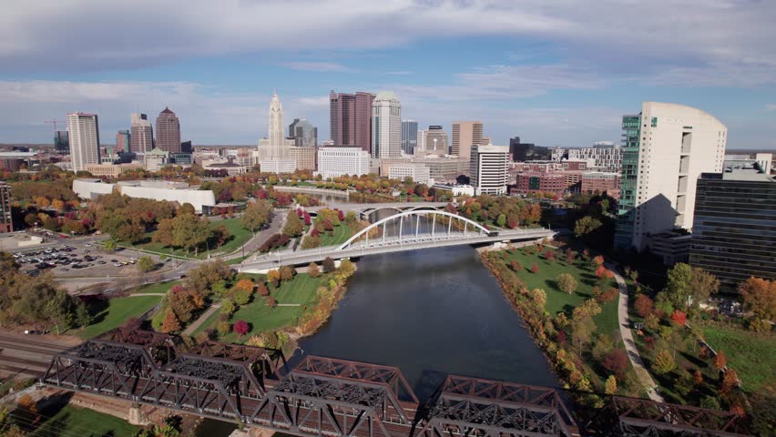 American midwestern city buildings, towers, and business of Columbus, OH in central Ohio with Scioto Mile, Franklinton, and downtown center buildings along river during a sunny fall and autumn day