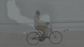 Senior man pedaling blue bicycle along coast for leisure, tech overlays partially covering rider. Cyclist, beach, elderly, bike, moody, overcast, bokeh - Powered by Shutterstock - Get 15% off with code: PIKWIZARD15