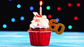 Delicious birthday cupcake with a burning candle and number 60 topper, glowing warmly against a multicolored lights background — celebrating a joyful 60th birthday milestone. - Powered by Shutterstock - Get 15% off with code: PIKWIZARD15