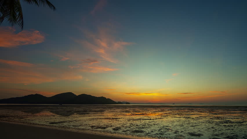 Time lapse The golden twilight settles over the tranquil shoreline, painting soft reflections on the still water. The beauty of dusk whispers peace as day transforms into a dreamlike night.