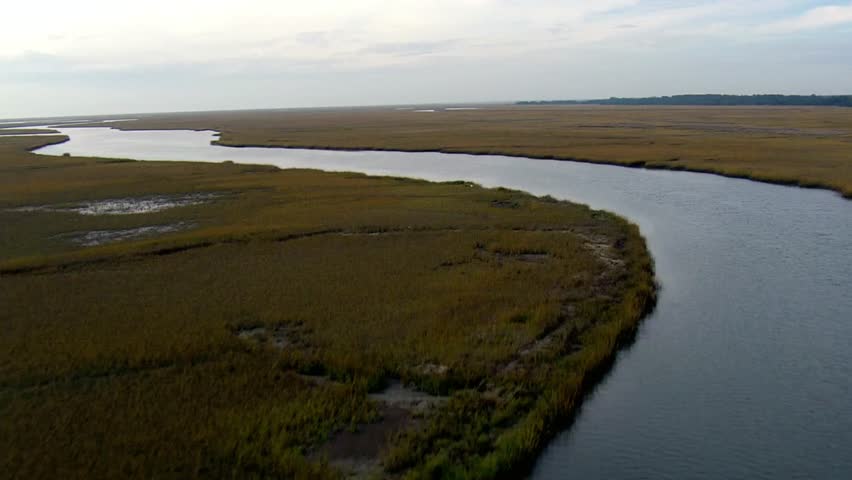 Aerial view of winding rivers and marshland under a cloudy sky landscape shot