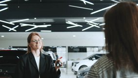 Saleswoman discussing car options with happy cuople clients in an automobile dealership while facilitating a test drive consultation - Powered by Shutterstock - Get 15% off with code: PIKWIZARD15