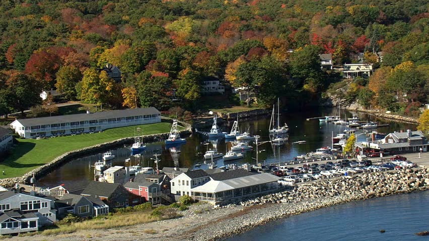 Scenic harbor view with boats autumn foliage and coastal buildings in Maine USA
