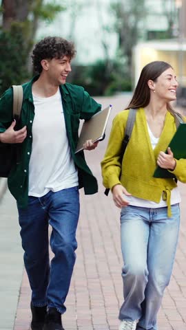 Two happy University students running on campus going to classes, celebrating exams