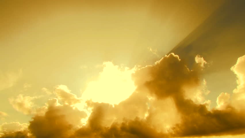 Beautiful yellow cloudscape with large, building clouds and sunrise breaking through cloud mass. Royalty-Free Stock Footage #3936626