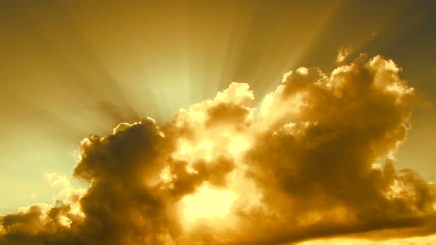 Beautiful yellow cloudscape with large, building clouds and sunrise breaking