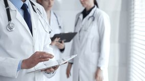 Healthcare professional using a digital tablet for patient data management, doctors collaborating on medical records, modern clinic team focusing on health technology - Powered by Shutterstock - Get 15% off with code: PIKWIZARD15