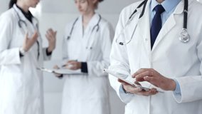 Healthcare professional using a digital tablet for patient data management, doctors collaborating on medical records, modern clinic team focusing on health technology - Powered by Shutterstock - Get 15% off with code: PIKWIZARD15