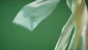 Lightweight translucent fabric in soft pastel colors billows and floats gracefully against a solid green background, creating a serene and elegant abstract motion. - Powered by Shutterstock - Get 15% off with code: PIKWIZARD15