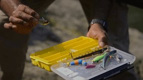 Close-up of hands of anonymous African American father and child holding a tackle box, selecting colorful fishing baits and hooks together during a family camping trip. - Powered by Shutterstock - Get 15% off with code: PIKWIZARD15