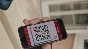 Vertical close-up of a delivery worker holding a smartphone with a QR code while a customer scans it to make a payment outdoors on a house porch. - Powered by Shutterstock - Get 15% off with code: PIKWIZARD15