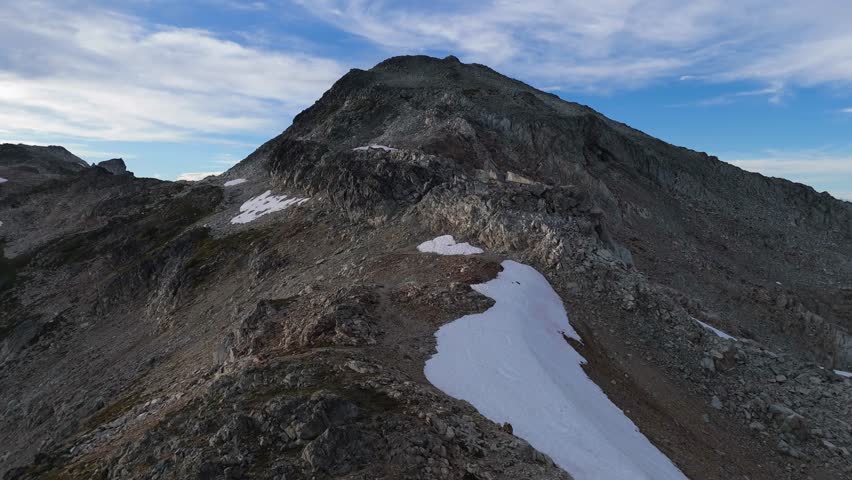 Majestic Rocky Mountain Peak with Snow Patches under Blue Sky in British Columbia, Canada