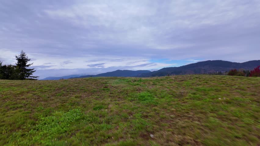 Panoramic View of Lush Green Hills and Majestic Mountains Overlooking a Quiet Town in British Columbia, Canada