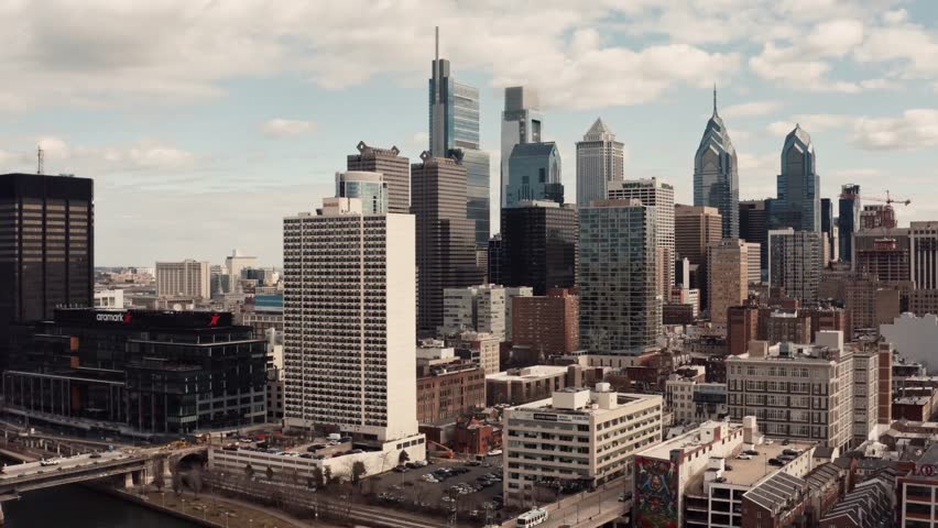 Aerial view of city skyline under cloudy sky showing tall office buildings.