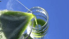 A slow-motion video captures a smooth stream of vibrant green juice pouring from a jug into a clear glass. Florida, November 2, 2025 - Powered by Shutterstock - Get 15% off with code: PIKWIZARD15
