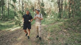 Jovial hikers share laughs, Two companions converse happily along wooded trail during daytime, Lively friends in casual attire engaging in animated discussion beneath towering trees on sunny nature - Powered by Shutterstock - Get 15% off with code: PIKWIZARD15