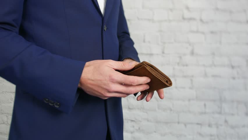 An empty wallet being opened by a business man showing that he has no money 4k
