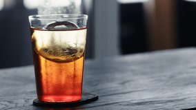 Slow motion man pour tonic water over clear ice ball in tumbler glass on black oak table - Powered by Shutterstock - Get 15% off with code: PIKWIZARD15