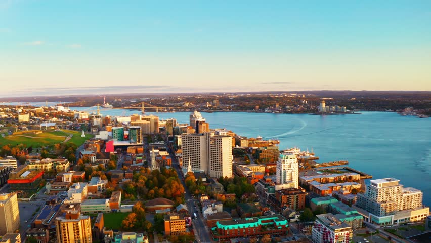 Sunrise aerial drone shot over Halifax downtown, Nova Scotia, Canada. High view of the golden landscape and sea at down as the sun is rising in the early morning 4k