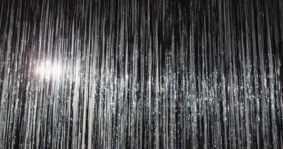 Mysterious man pretending being magician, wearing black hat, purple costume and white gloves, appearing over shiny silver background, participating in performance during party on holiday