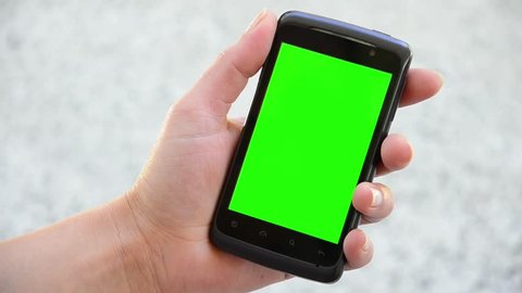 Holding Touchscreen Device, Close-up of female hands using a smart phone. chroma-key, green-screen