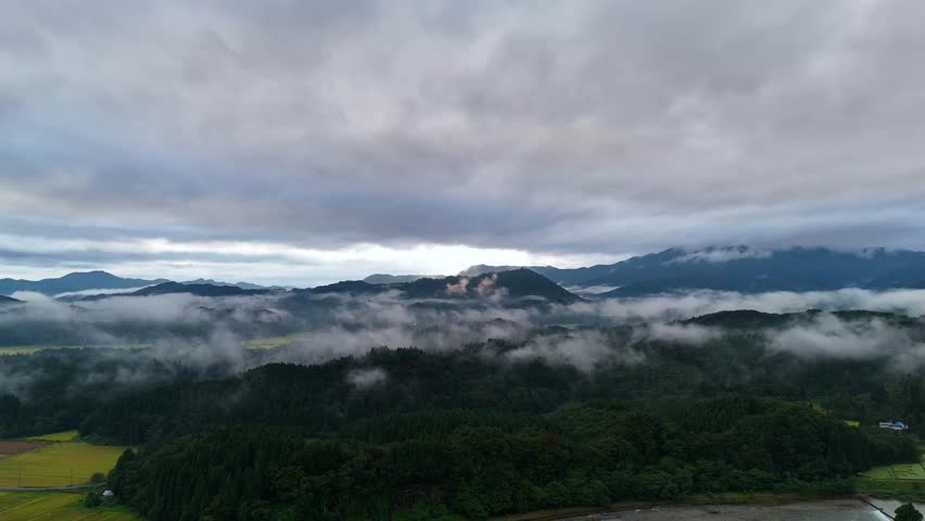 Aerial view of a rural landscape in Tohoku with fog forming near the ground in the early autumn morning.