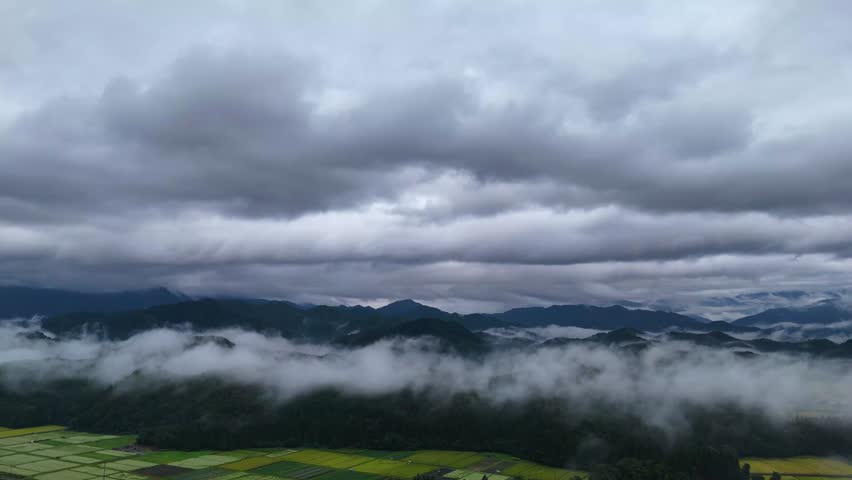 Aerial view of a rural landscape in Tohoku with fog forming near the ground in the early autumn morning.