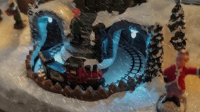 Holiday train set spins through festive scenery with bright lights and falling snow for a magical winter wonderland experience - Powered by Shutterstock - Get 15% off with code: PIKWIZARD15