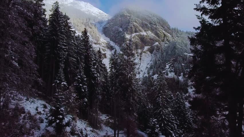  A breathtaking aerial shot over the winter landscape of Tyrol, Austria. Snow-capped Alpine peaks tower above the city of Innsbruck and frost-covered forests in the valley below.