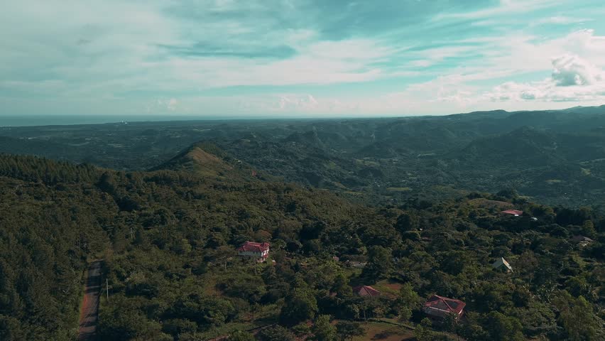 A beautiful mountain view with a small town in the distance. The sky is clear and the sun is shining