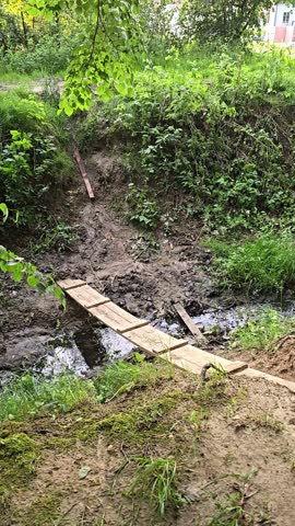 a bridge over a ditch, a homemade wooden bridge over a river