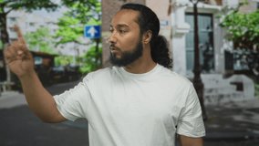 Man pointing finger on street wearing white tshirt and beard; direction instruction guidance determination. - Powered by Shutterstock - Get 15% off with code: PIKWIZARD15
