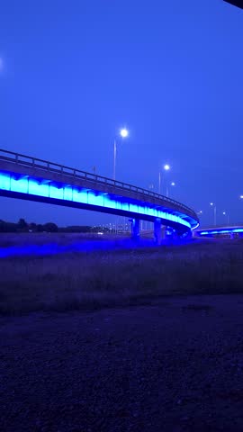 Filming a illuminated city interchange at night, the blue illumination of the overpass