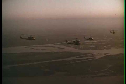 1960s - Good montage of helicopters flying in formation on a mission and landing in rice paddy.