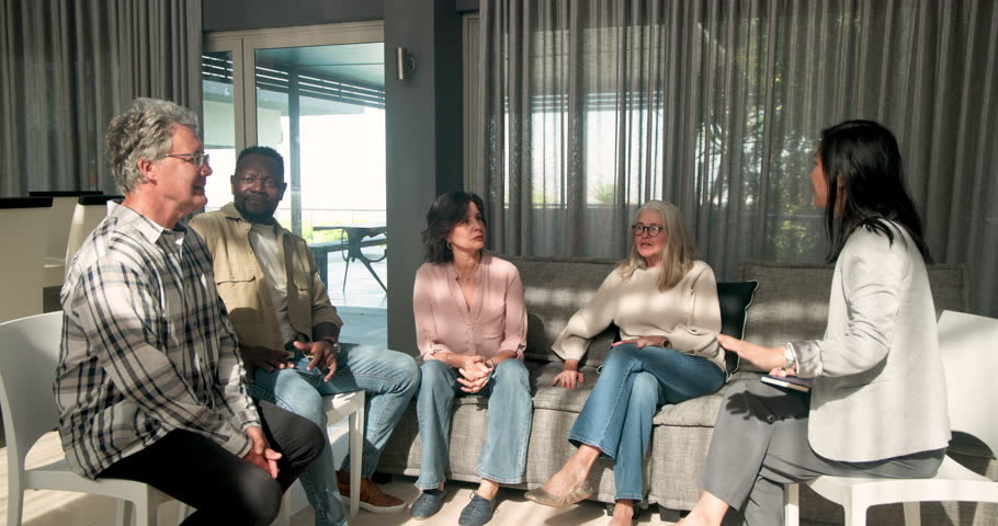 Therapist addressing male and female patients standing and talking in session. Counseling, therapy, communication, support, mental health, discussion