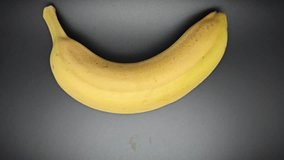 A bright yellow banana is centered on a black background, and a child’s hand reaches in to grab it and pull it away - Powered by Shutterstock - Get 15% off with code: PIKWIZARD15