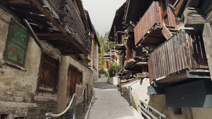 Static shot of old wooden houses and narrow alley in historic Zermatt, Switzerland. Traditional Swiss alpine architecture showcasing the charm and heritage of a mountain village