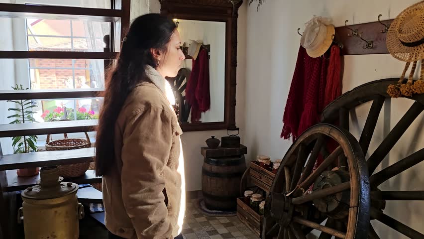 A woman in a hat comes out of a room, the lighthouse keeper