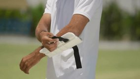 Close-Up Shot of Cricketer Wearing Elbow Pad — Athlete Preparing for Match, Putting on Protective Gear, Sports Safety Equipment, and Professional Cricket Player Readiness in 4K Ultra HD - Powered by Shutterstock - Get 15% off with code: PIKWIZARD15