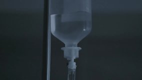 Close up of an intravenous drip bag hanging on a metal pole, with saline solution flowing into a tube for medical treatment in a hospital room, illustrating healthcare and recovery concepts - Powered by Shutterstock - Get 15% off with code: PIKWIZARD15