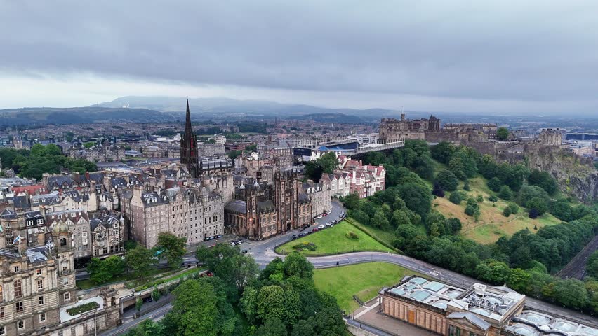 Overlook of Old Town Edinburgh Scotland with Edinburgh Castle on a cloudy day showcasing city buildings and green spaces