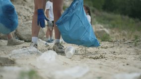 Volunteers working together collecting bottles. People uniting for environment by picking up bottles. Group volunteers removing bottles from nature. Volunteers clean area together gathering bottles. - Powered by Shutterstock - Get 15% off with code: PIKWIZARD15