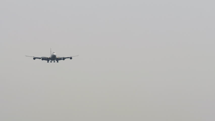 Large cargo aircraft on final approach, front view long shot, set against a clear blue sky. Perfect for aviation, freight, and global transportation themes