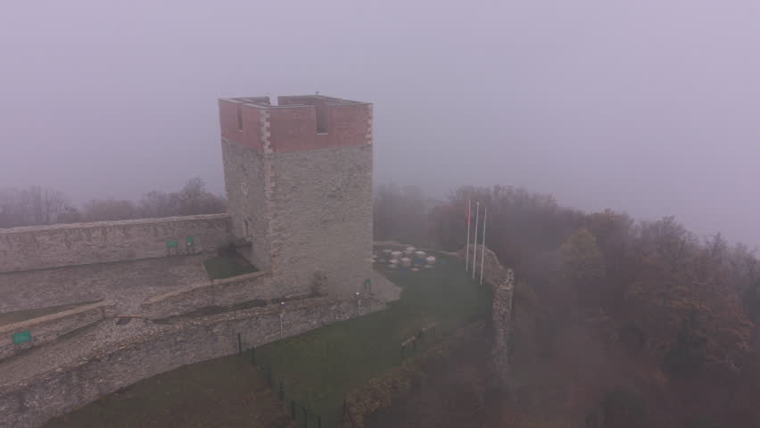 4K drone orbit around Medvedgrad Fortress from alternate angle in fog, Zagreb, Croatia. D-LOG M, DJI Mini 5 Pro. Cinematic aerial footage for documentary use.