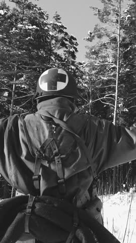 Historical Re-enactment Black And White Video. 4K Re-enactor Dressed As American Soldier Medic Of USA Infantry Of World War II Come Out Of Ambush With Hands Up Surrender To Captivity In Winter Day.
