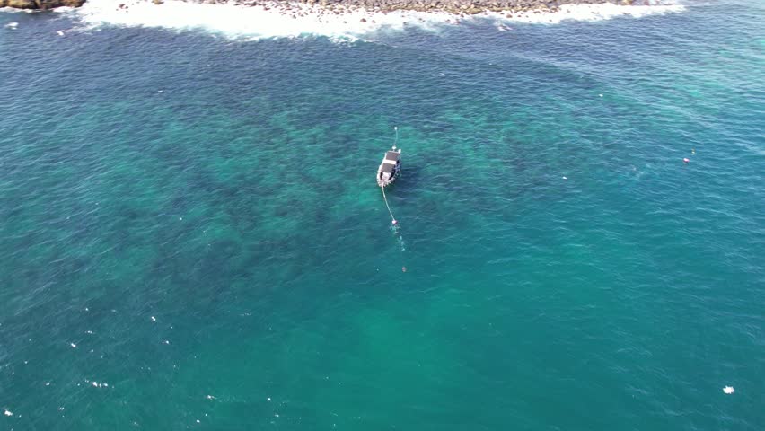 Elevated view of small tourist boat between Cook Island and Fingal Head causeway, northern New South Wales, Australia