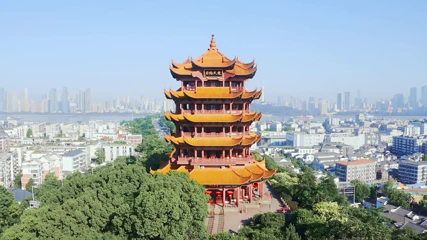 Yellow Crane Tower standing tall against the Wuhan skyline on a clear sunny day, showcasing historic Chinese architecture and cityscape views.